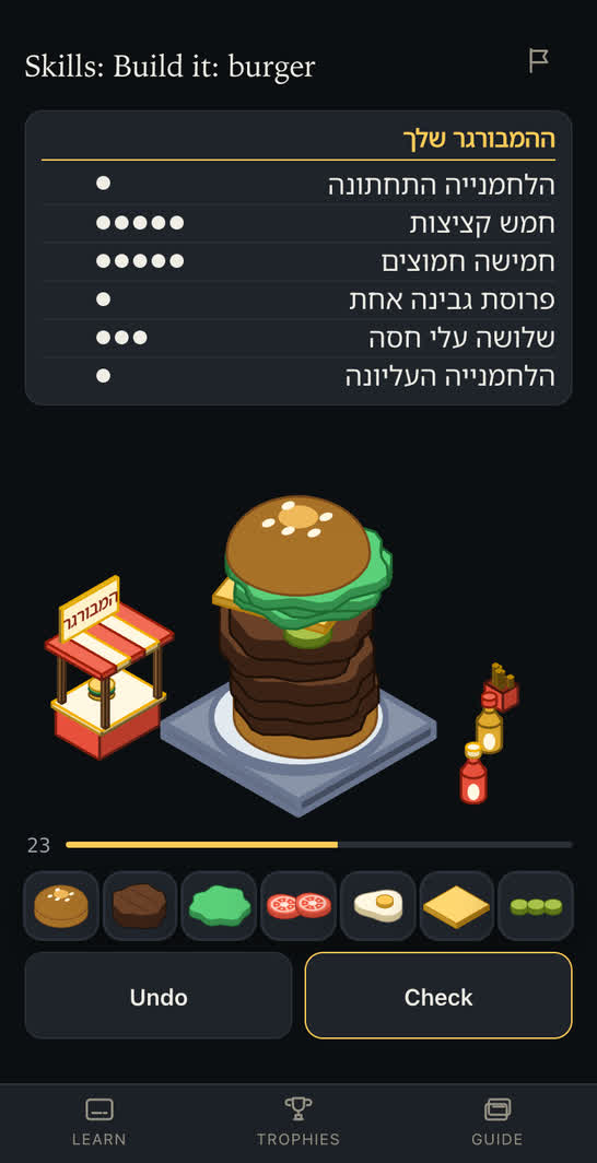 Build it: burger. An order in Hebrew above a tall burger stacked on its plate beside the burger stand, with the pictures to build it from along the bottom.